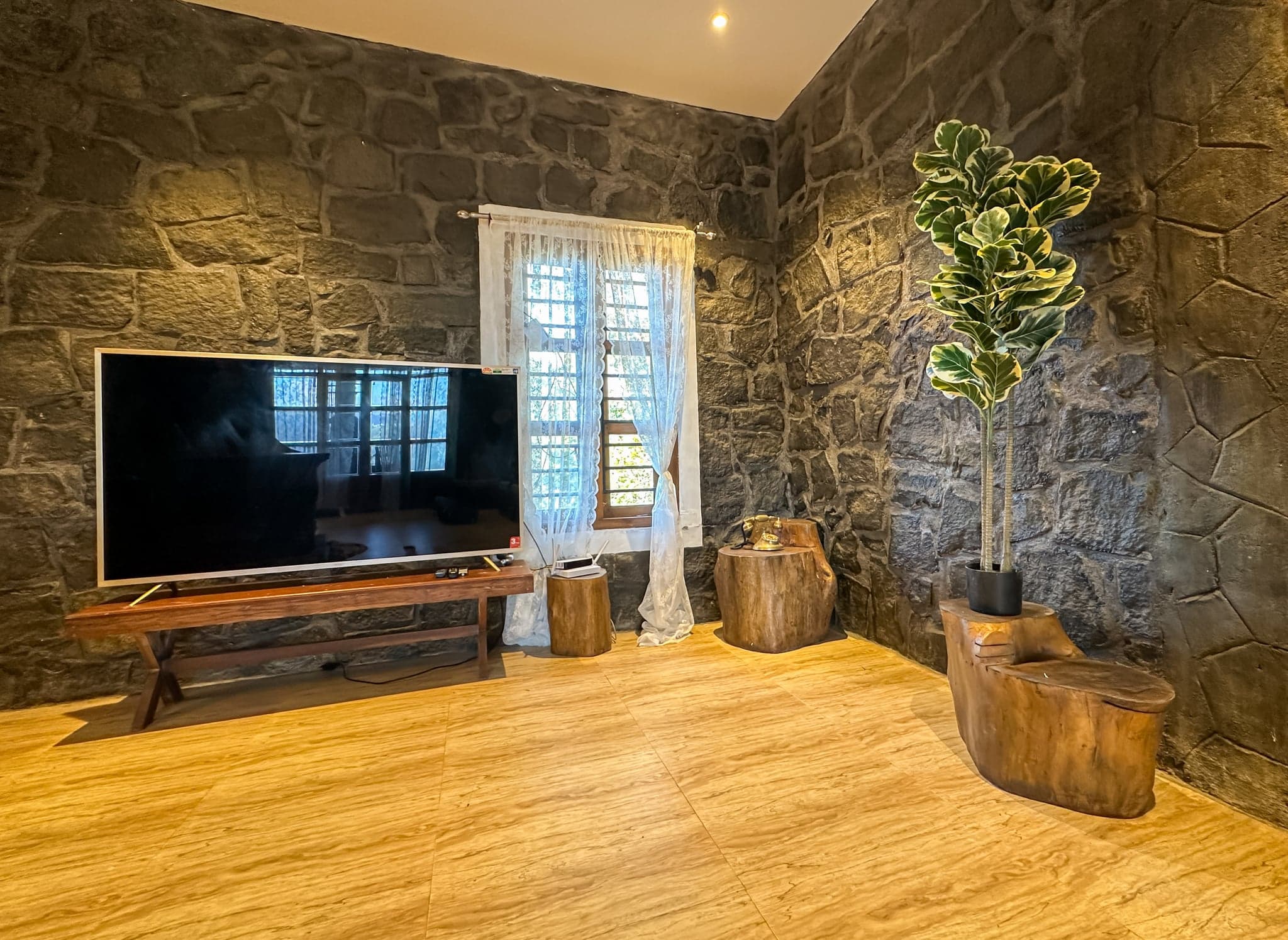 TV lounge with stone walls at The Sanctuary by Heyday, Panchalimedu, Idukki, Kerala