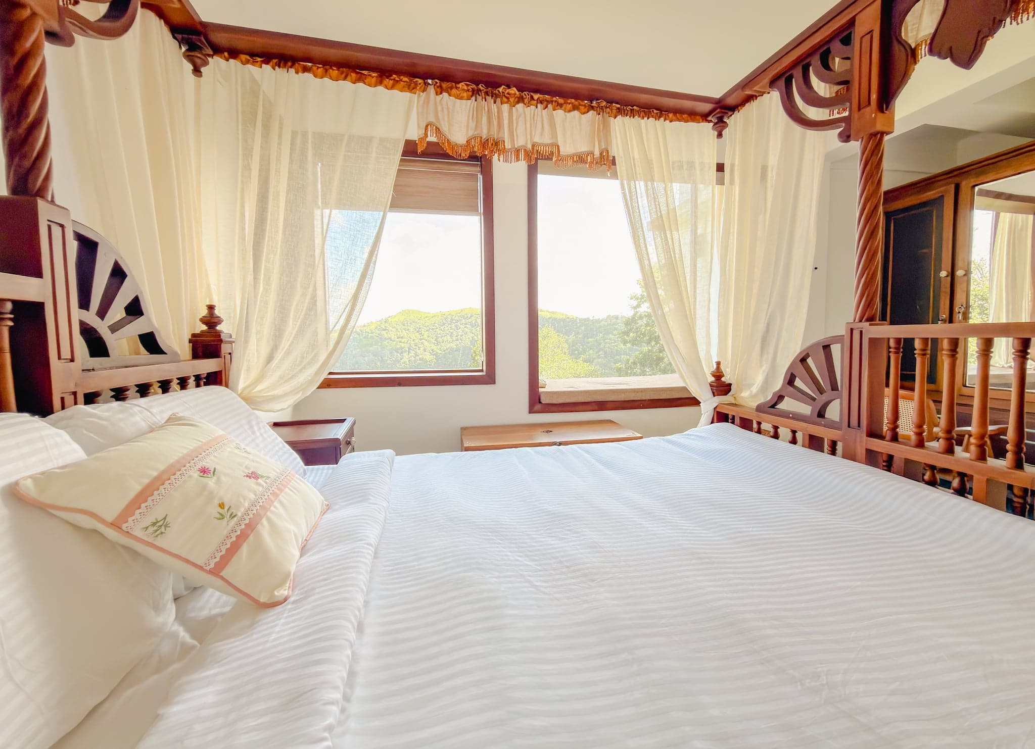 Four-poster bed by the window at The Sanctuary by Heyday, Panchalimedu, Idukki, Kerala