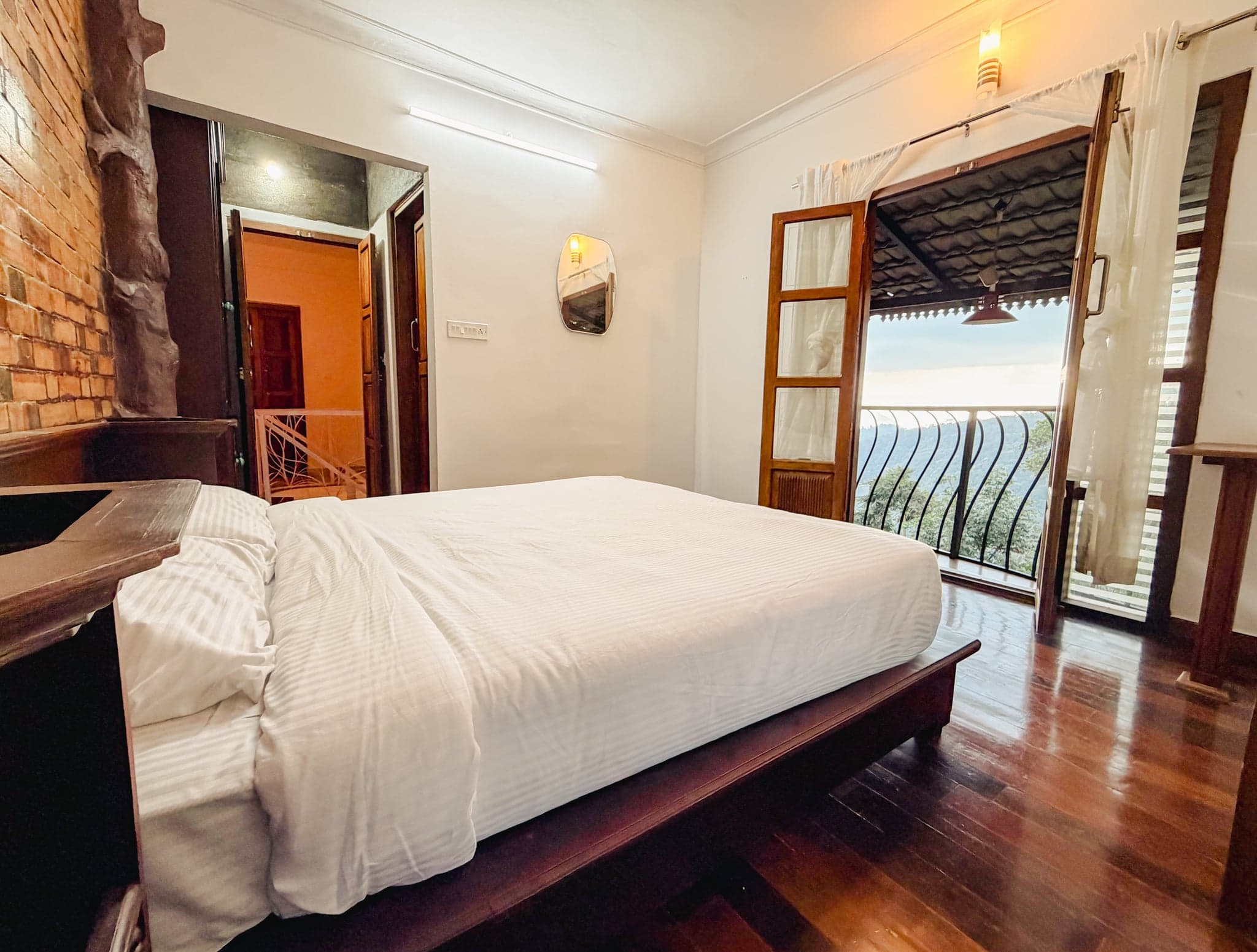 Bedroom with a balcony over the valley at The Sanctuary by Heyday, Panchalimedu, Idukki, Kerala