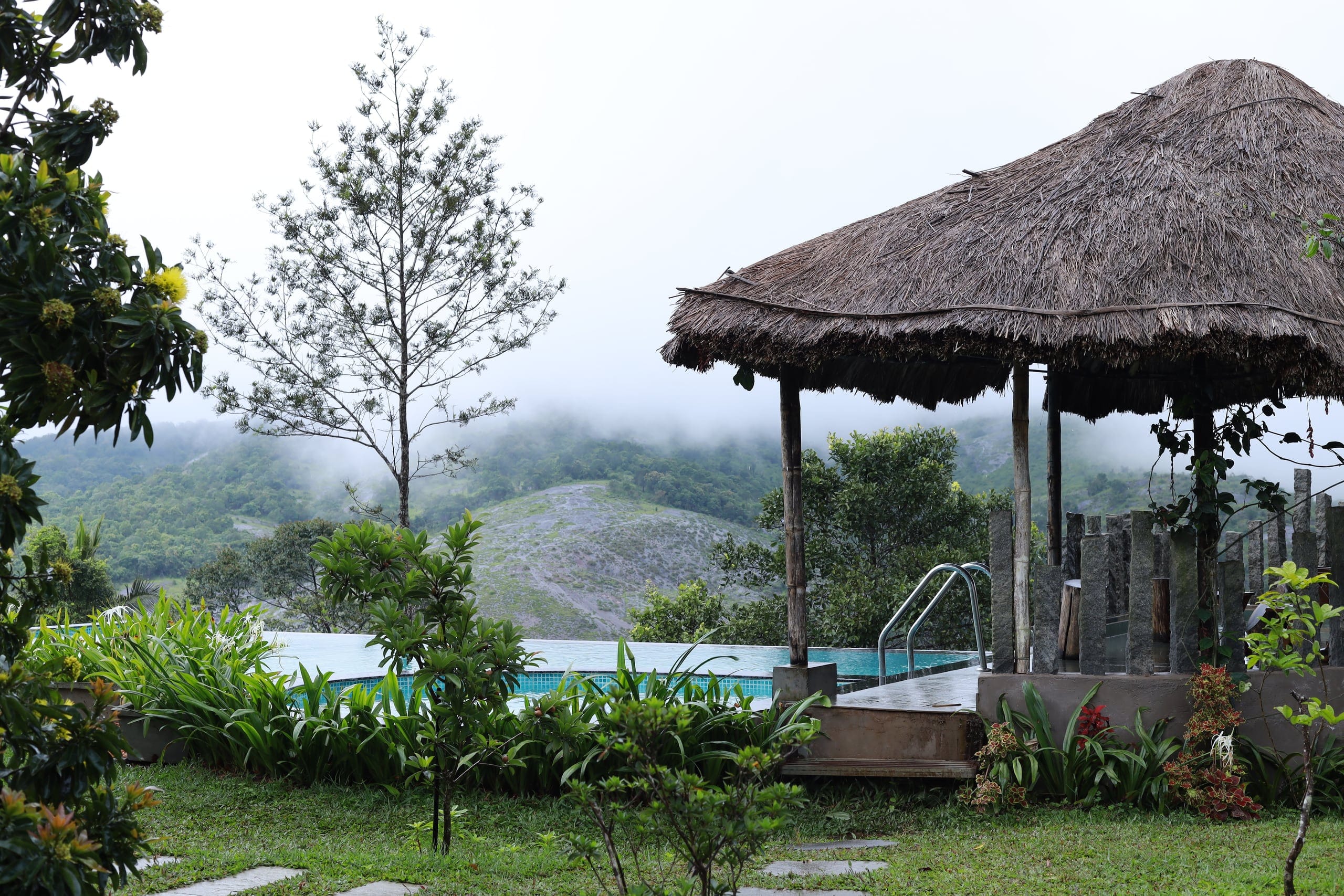 Infinity pool and thatched gazebo over the misty valley at Heyday Vagamon, Vagamon, Idukki, Kerala