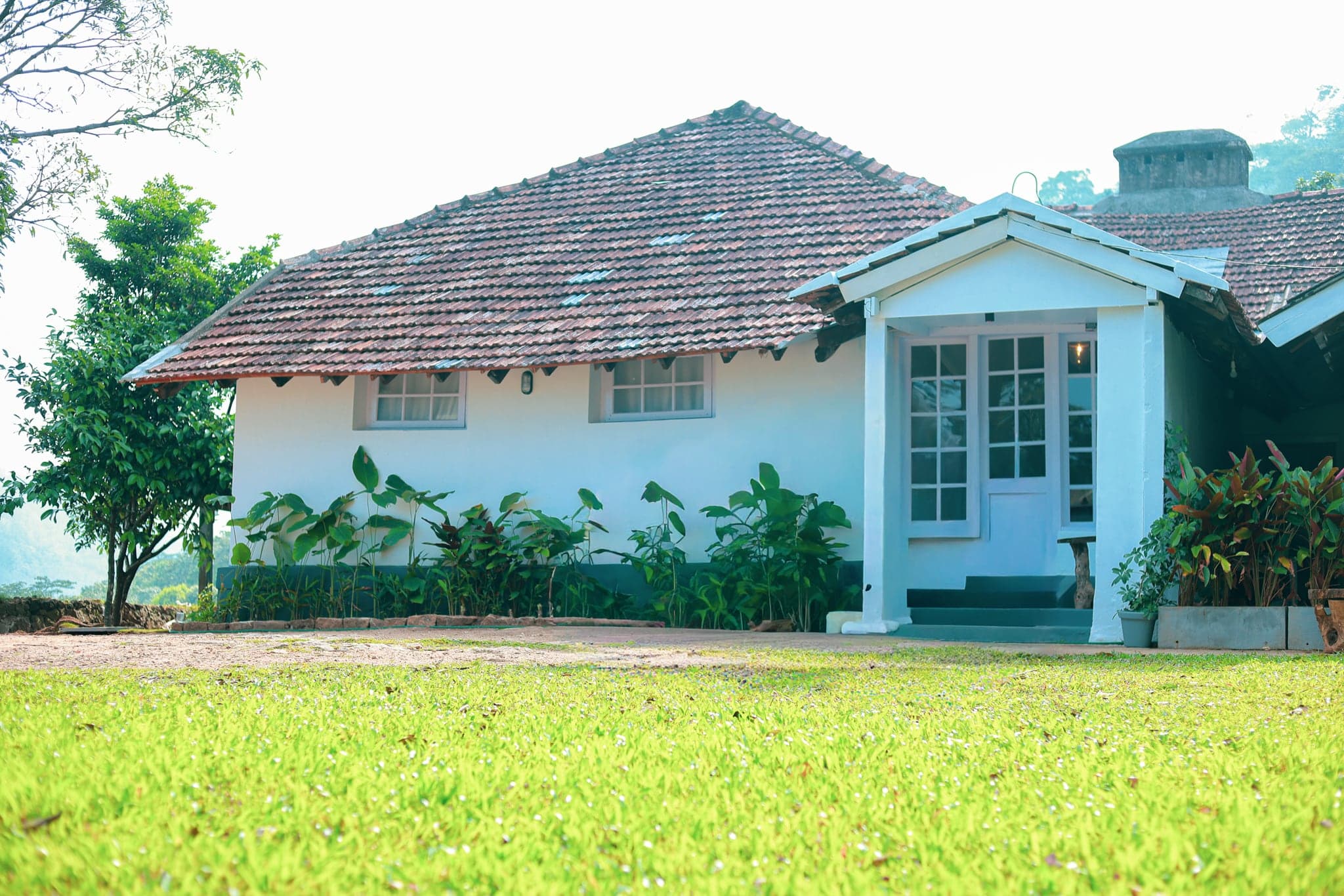 Tiled-roof 1930s planter's bungalow and lawn at Heyday Planter's Portico, near Thenmala, Kollam, Kerala