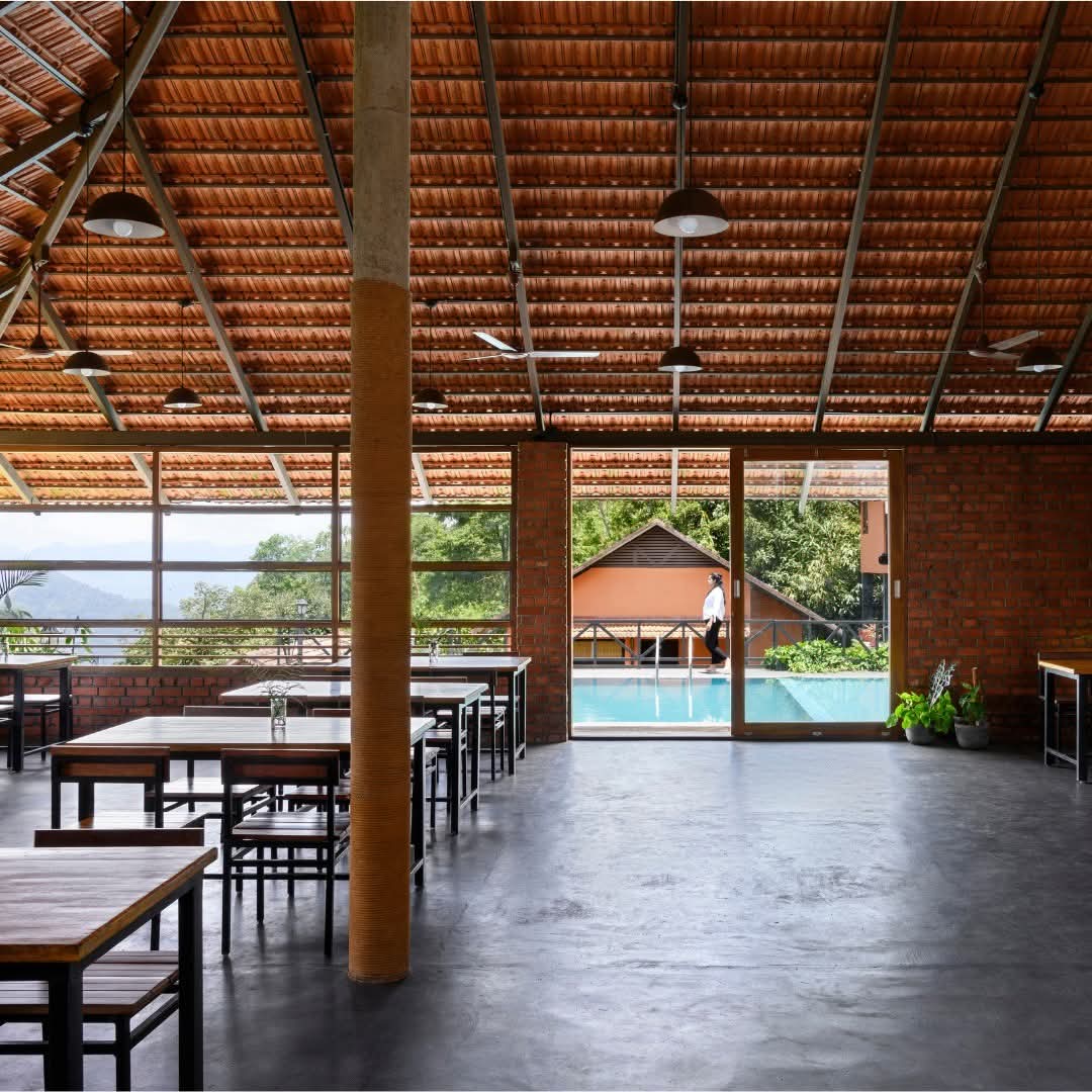 Open-air dining hall under a terracotta-tiled roof beside the pool at Heyday Thazhvaram, Panchalimedu, Idukki, Kerala