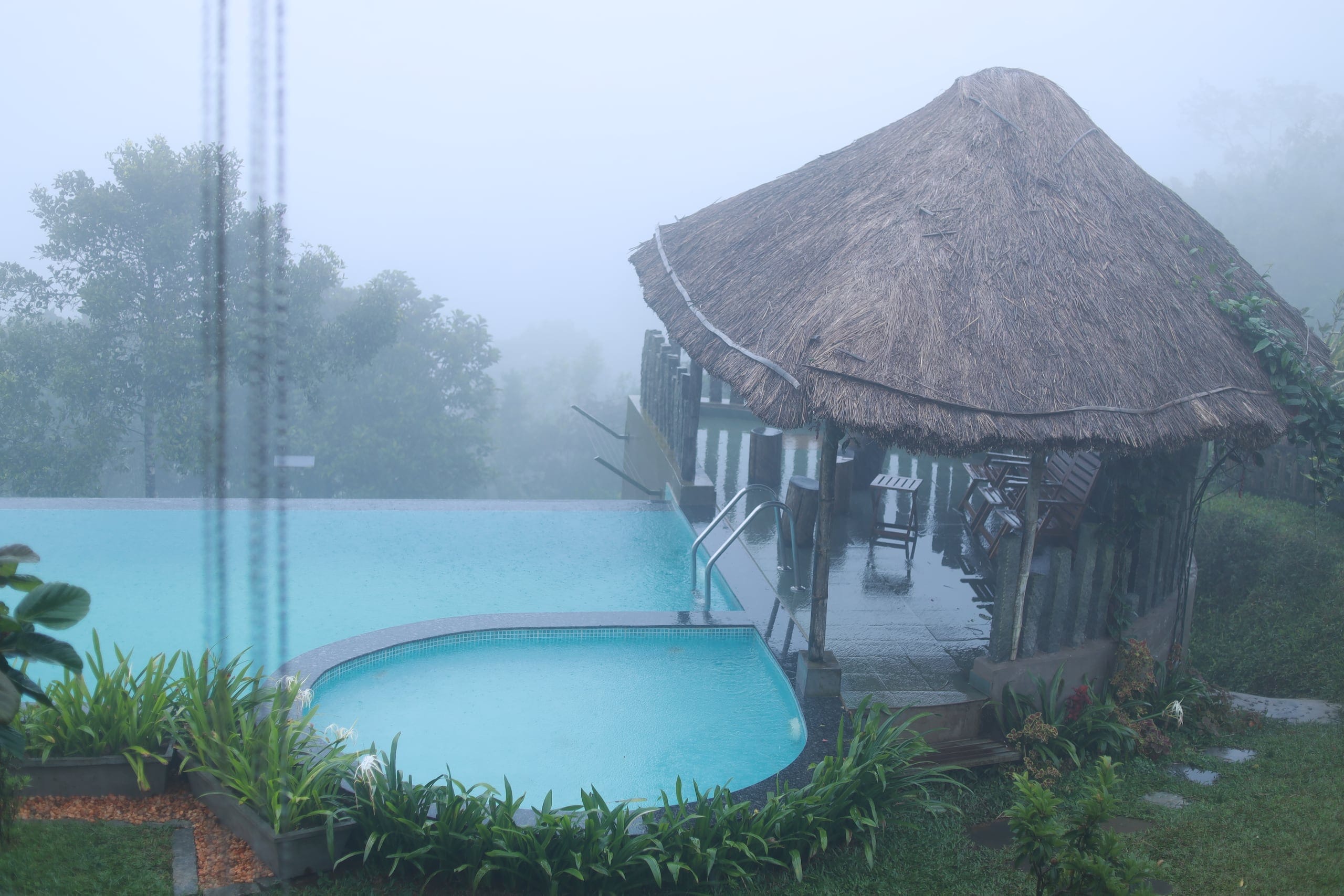 Poolside thatched hut in the morning mist at Heyday Vagamon, Vagamon, Idukki, Kerala